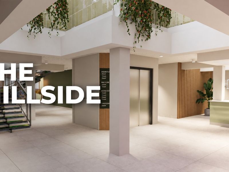 Modern commercial building lobby featuring a reception area, elevator access, tenant directory, and contemporary architectural finishes with an open-plan layout.