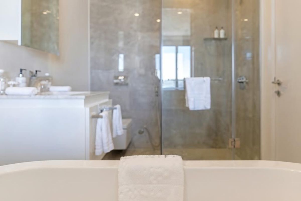 Modern bathroom featuring a freestanding bathtub, a glass-enclosed shower, and a sleek vanity cabinet with contemporary wall-mounted fixtures.