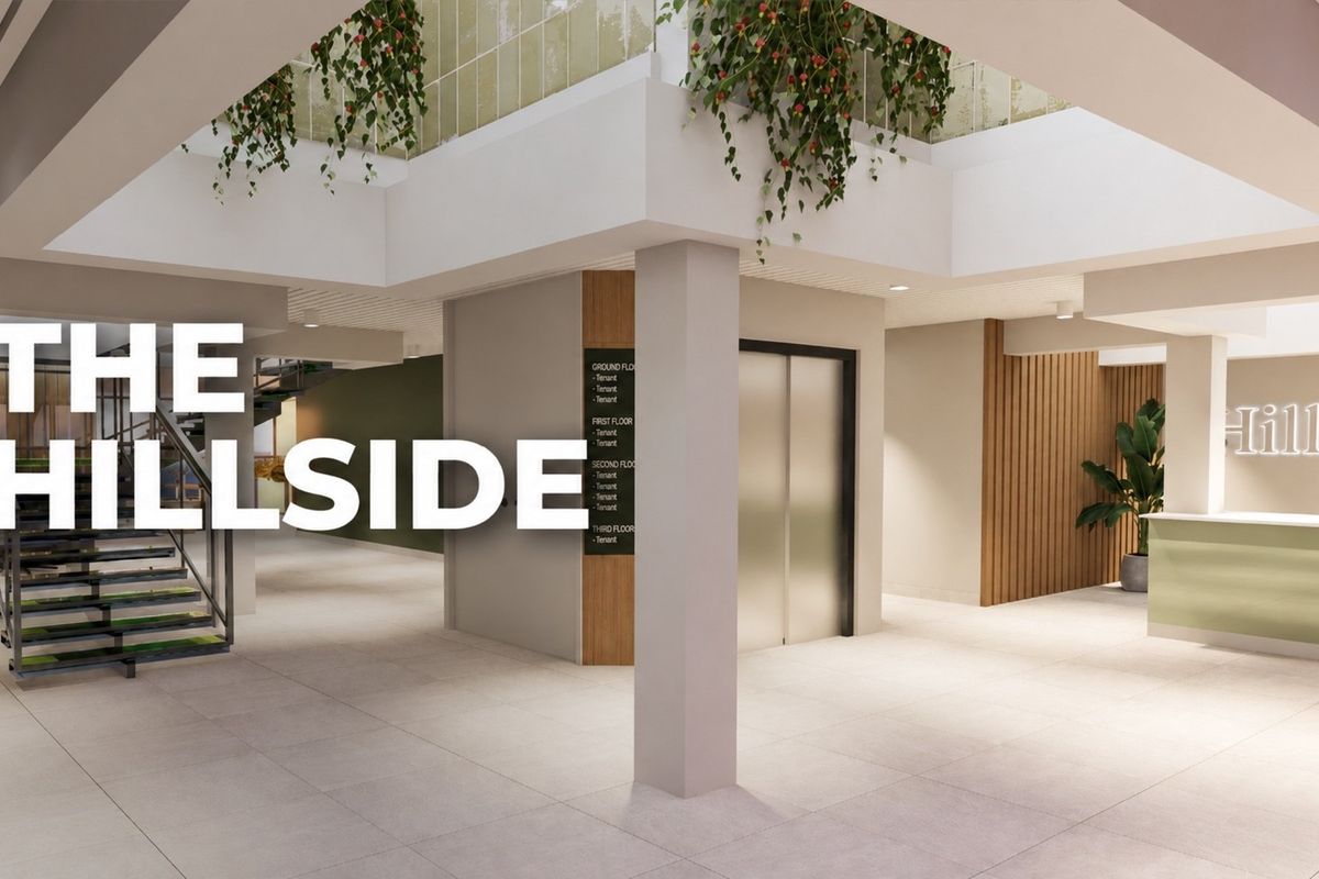Modern commercial building lobby featuring a reception area, elevator access, tenant directory, and contemporary architectural finishes with an open-plan layout.