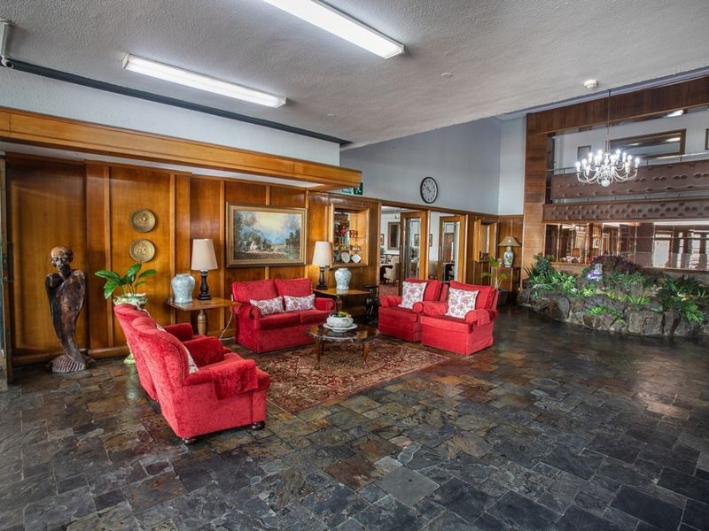 Spacious communal living area featuring traditional wood paneling, slate tile flooring, and a built-in stone planter feature.