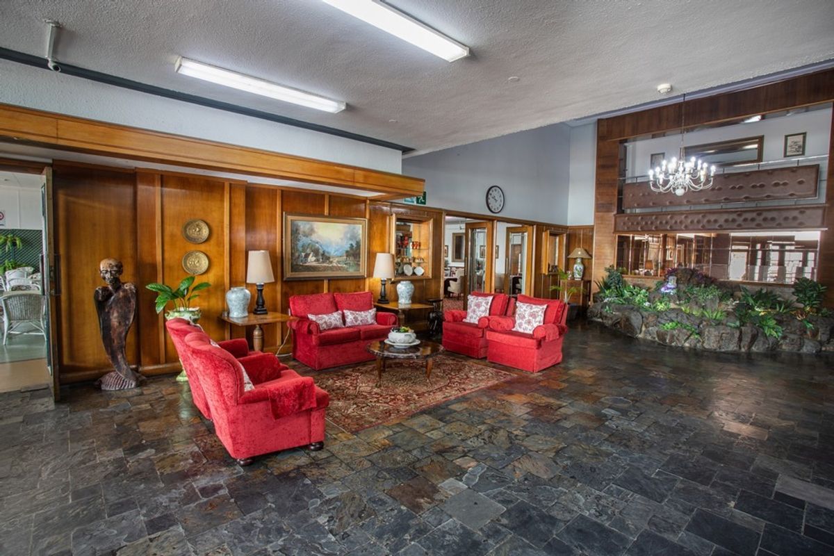 Spacious communal living area featuring traditional wood paneling, slate tile flooring, and a built-in stone planter feature.
