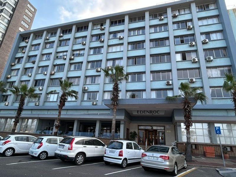Front elevation of the Edenroc retirement village building, featuring a multi-story facade with numerous external air conditioning units and a covered entrance.