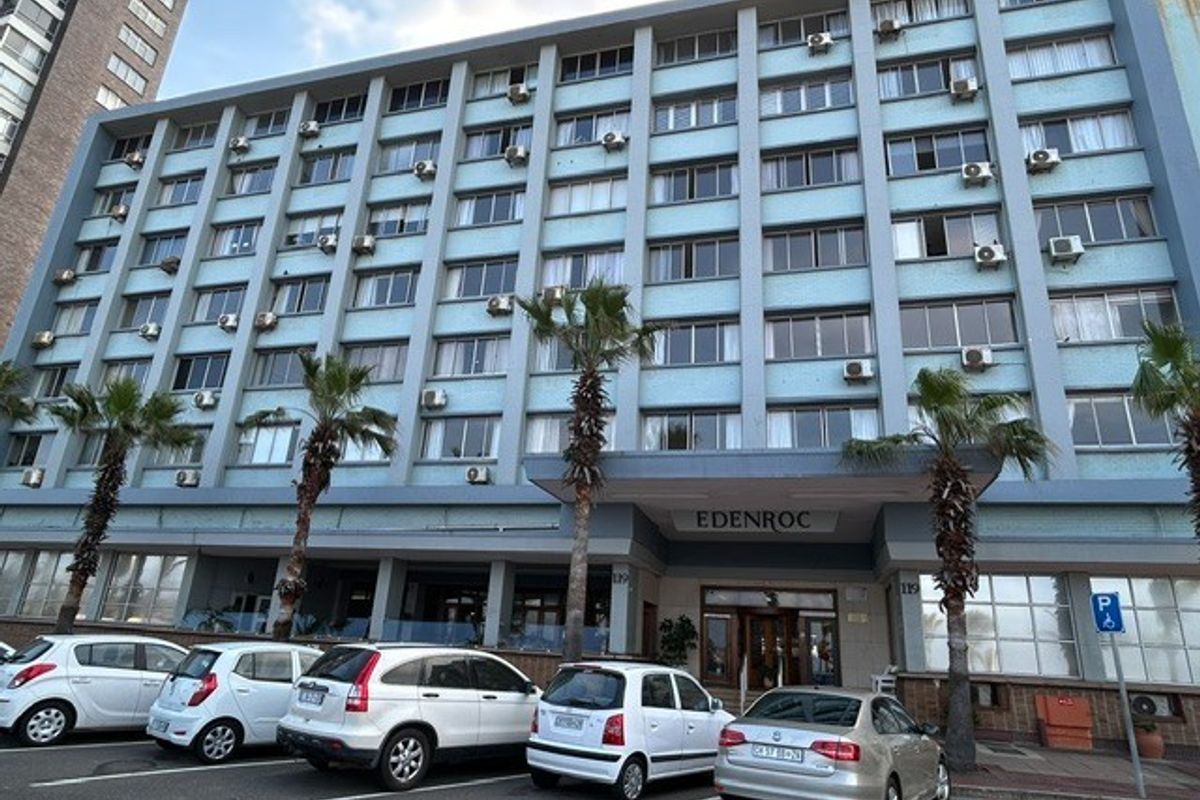Front elevation of the Edenroc retirement village building, featuring a multi-story facade with numerous external air conditioning units and a covered entrance.