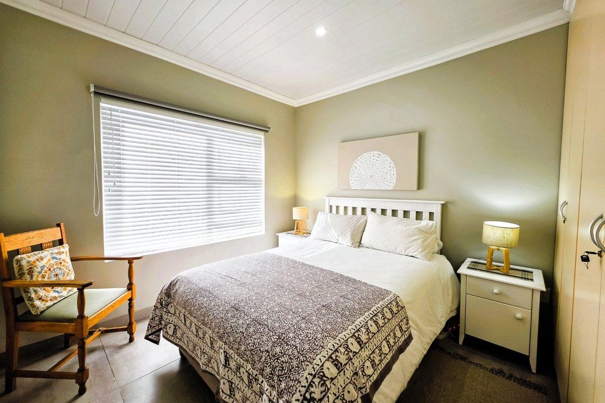 A well-maintained bedroom featuring tiled flooring, a tongue and groove ceiling with recessed lighting, and a built-in wardrobe.