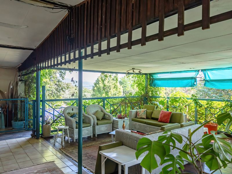 A covered outdoor patio featuring tiled flooring, timber ceiling detailing, and metal balustrades, offering a functional space for outdoor relaxation and entertaining.