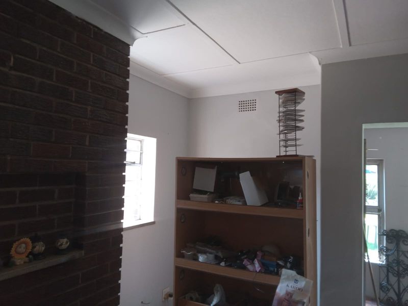 A living room area featuring a prominent brick fireplace and coved ceiling detailing.