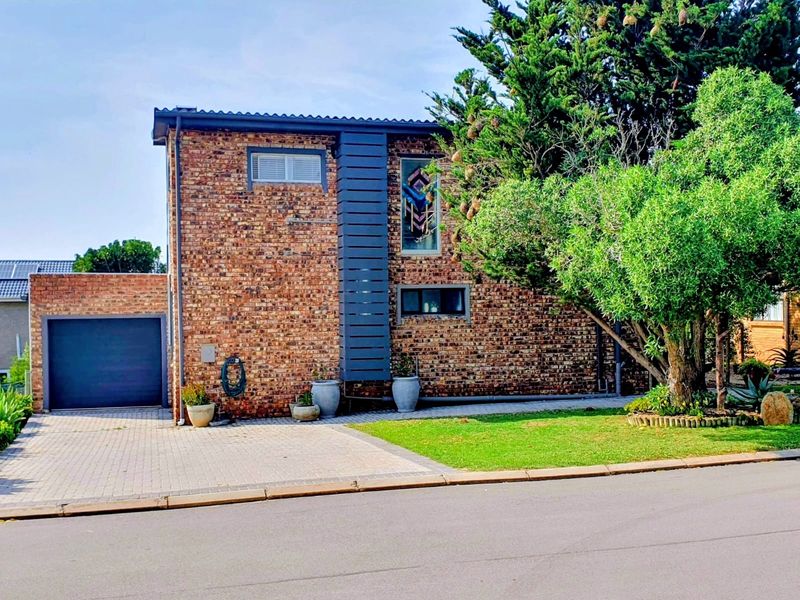 A well-maintained double-story face brick home featuring a paved driveway, integrated single garage, and established garden frontage.