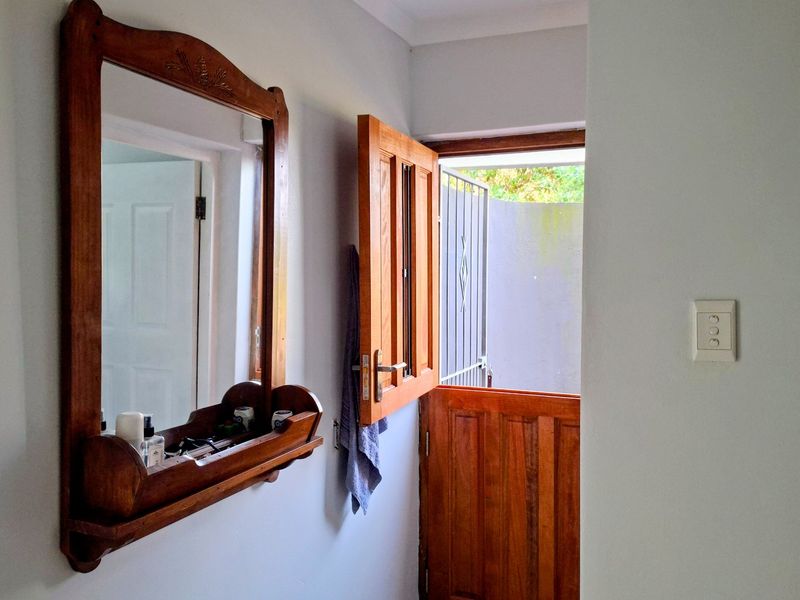 An entry area featuring a wooden stable door providing access to the exterior and a wall-mounted light switch.
