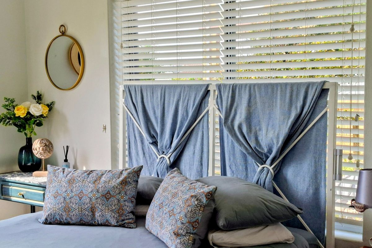 A cozy bedroom featuring a window with fitted venetian blinds, providing natural light and privacy.