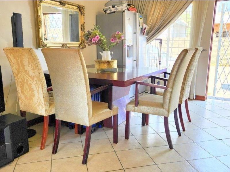 Dining area featuring tiled flooring and a sliding door with a security gate, providing direct access to the exterior.