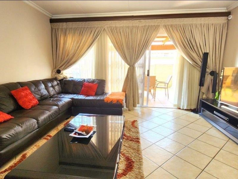 A comfortable living room featuring tiled flooring and a sliding glass door that provides direct access to the outdoor patio area.