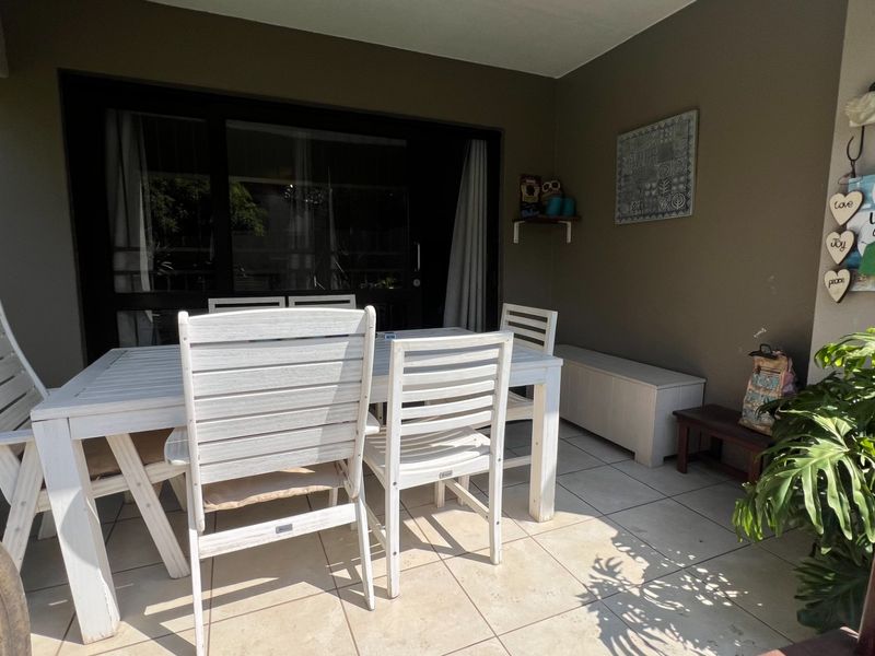A covered patio area featuring tiled flooring and large sliding glass doors providing access to the interior living space.