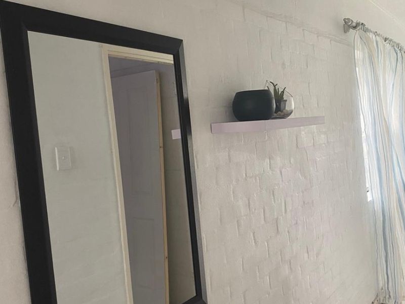 A simple hallway featuring painted brick walls and tiled flooring, providing a neutral foundation for interior design updates.