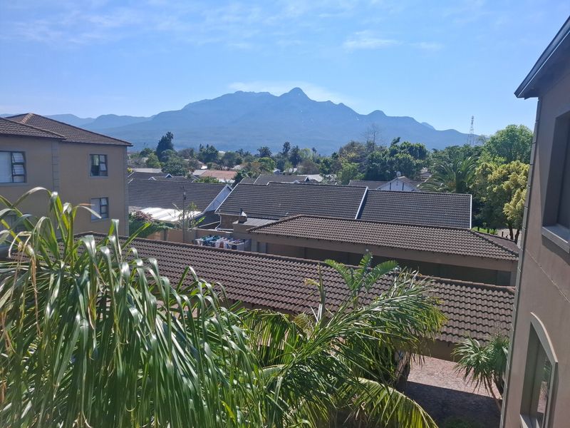 Elevated view overlooking a residential neighbourhood with a prominent mountain range in the background.