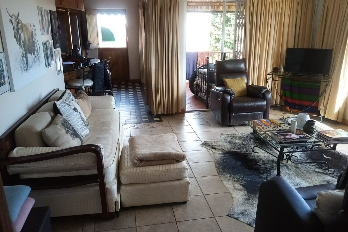 A living room featuring tiled flooring and a sliding glass door providing access to an outdoor patio area.