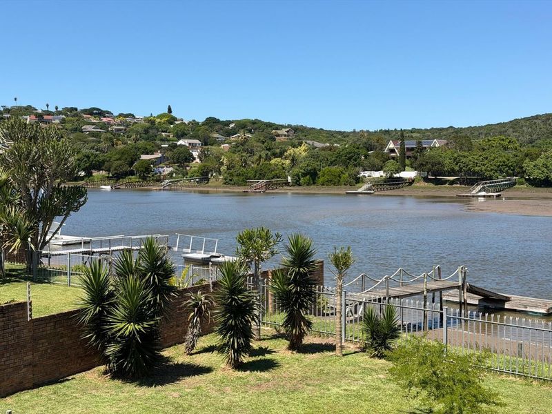 Scenic view overlooking the river estuary with private jetty access, landscaped garden, and secure boundary fencing.