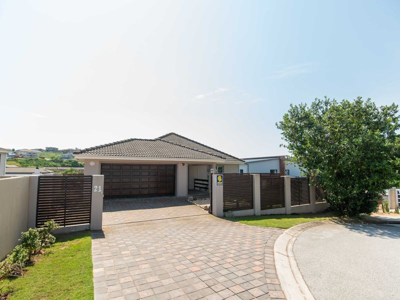 Front elevation of a modern house featuring a paved driveway, double garage, and secure timber slat boundary fencing.
