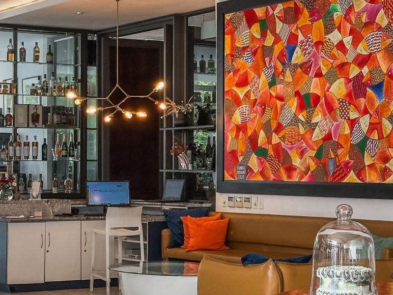 A well-appointed bar area featuring custom cabinetry, glass display shelving, stone countertops, and contemporary pendant lighting, creating a sophisticated atmosphere.