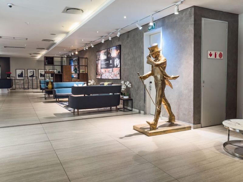A modern, well-maintained clubhouse lounge area featuring contemporary tiled flooring, professional track lighting, and a sophisticated textured feature wall.