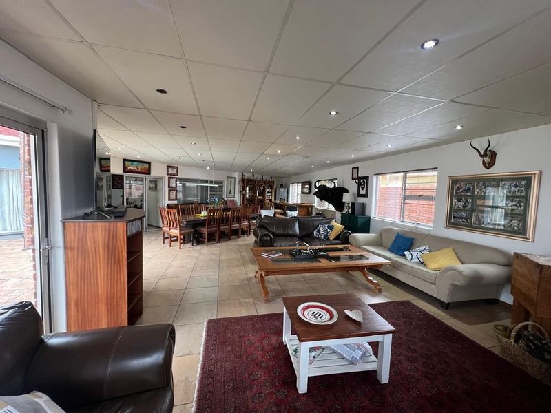Spacious open-plan living and dining area featuring tiled flooring, recessed lighting, and a suspended ceiling, offering a versatile layout for family living.