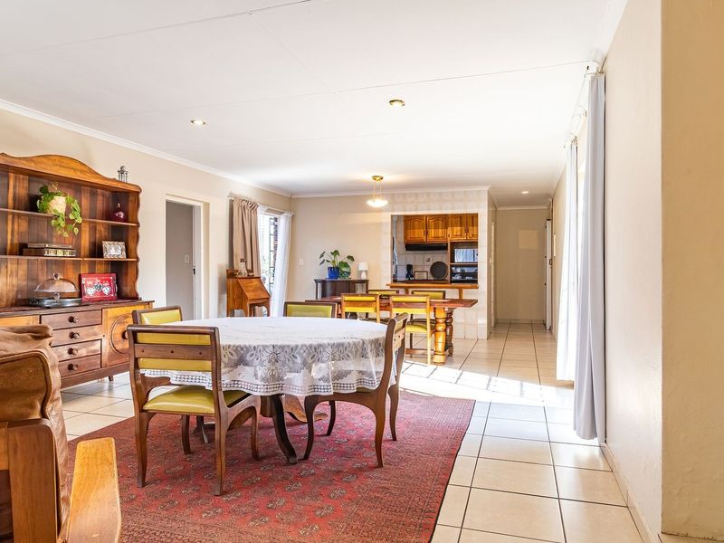 Spacious open-plan living and dining area featuring tiled flooring, recessed lighting, and a view through to the functional kitchen space.