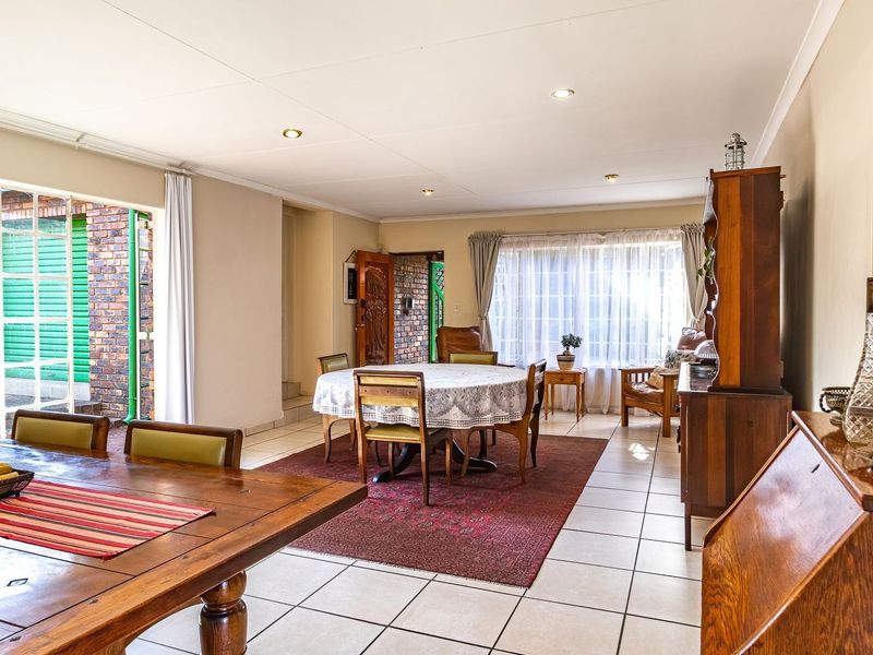 Spacious open-plan living and dining area featuring neutral walls, tiled flooring, and large sliding doors providing access to the exterior.