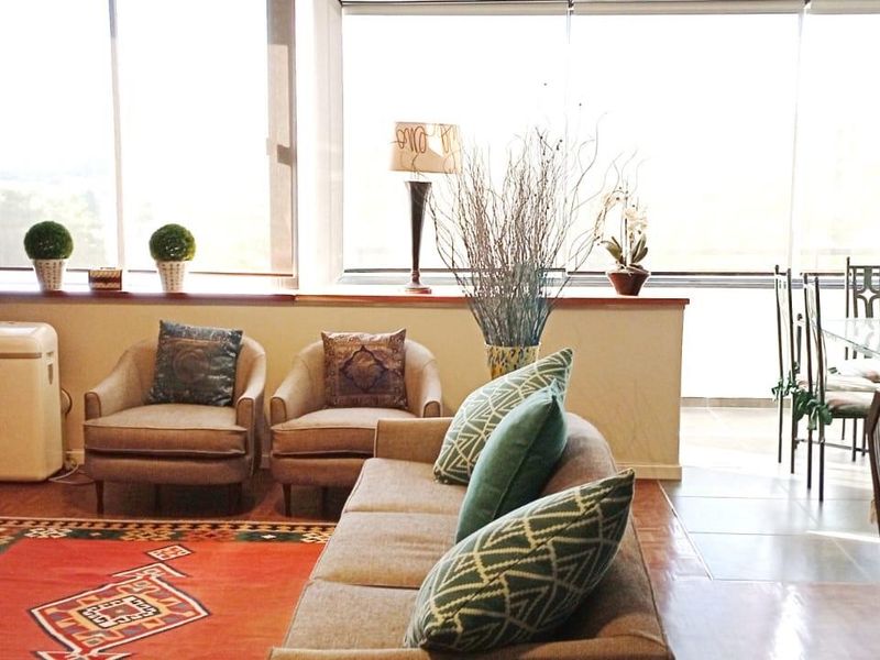 Spacious open-plan living and dining area featuring large windows that provide ample natural light and views.
