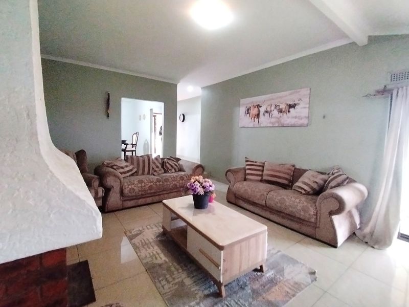 Spacious living room featuring a built-in fireplace and neutral tiled flooring, offering a comfortable and functional area for relaxation.