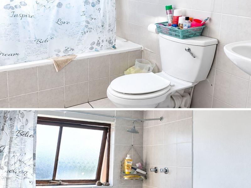 A functional bathroom featuring a bathtub, wall-mounted basin, toilet, and tiled finishes, providing a practical layout for daily use.