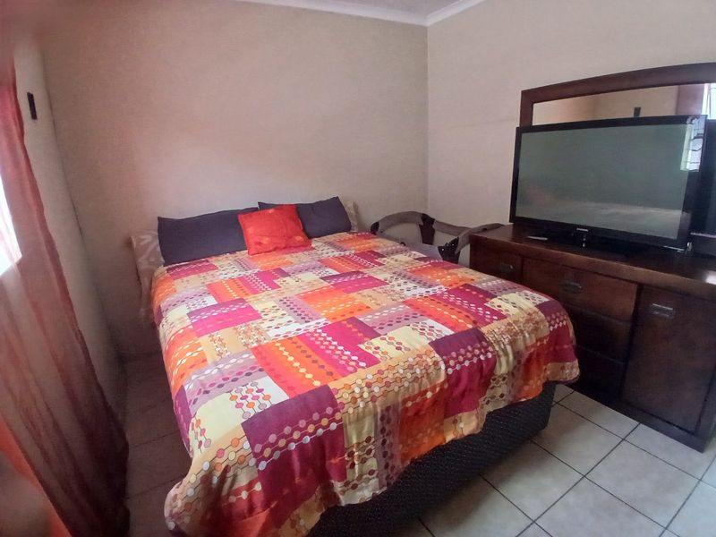 A standard bedroom featuring tiled flooring and neutral wall finishes, providing a functional space for rest.