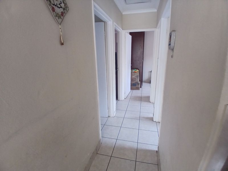 A functional hallway featuring tiled flooring and access to multiple rooms, providing a clean and neutral transition space within the home.