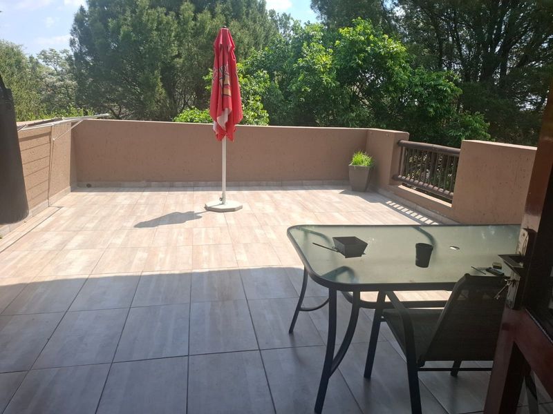 A spacious open-air balcony featuring tiled flooring and a combination of masonry and timber balustrades, offering a private outdoor area.