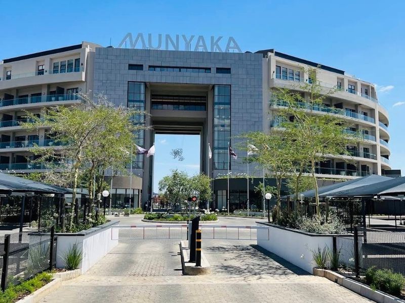 The main entrance and front facade of the Munyaka apartment complex, featuring a modern architectural design, paved driveway, and secure access point.