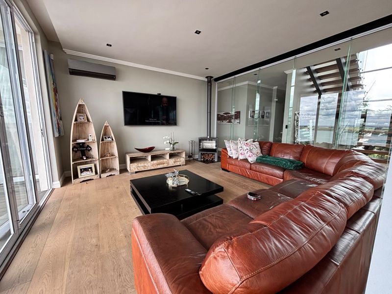 Spacious living room featuring wood flooring, a modern freestanding fireplace, recessed lighting, and large sliding glass doors leading to an outdoor area.