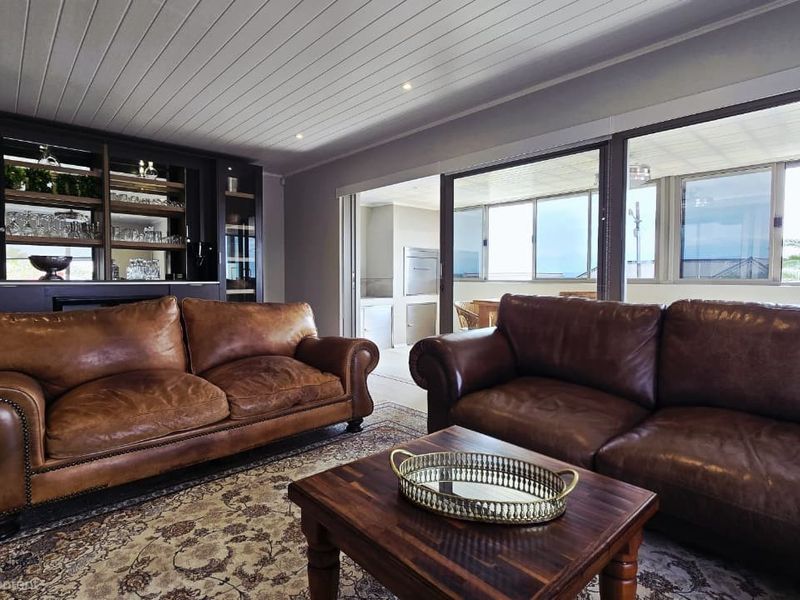 Spacious living room featuring built-in cabinetry, recessed lighting, and large sliding glass doors that open to an outdoor patio area.