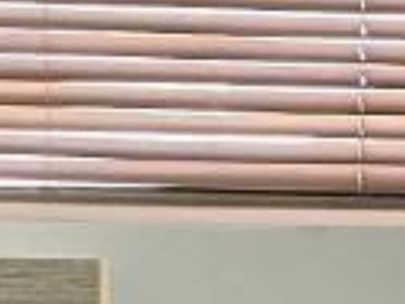 A close-up view of window blinds and a portion of a wall, providing insufficient information to identify the room or property features.