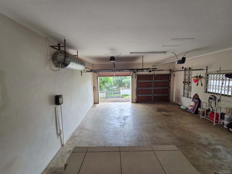Spacious double garage featuring concrete flooring, an installed geyser, and an automated garage door system with direct access to the driveway.