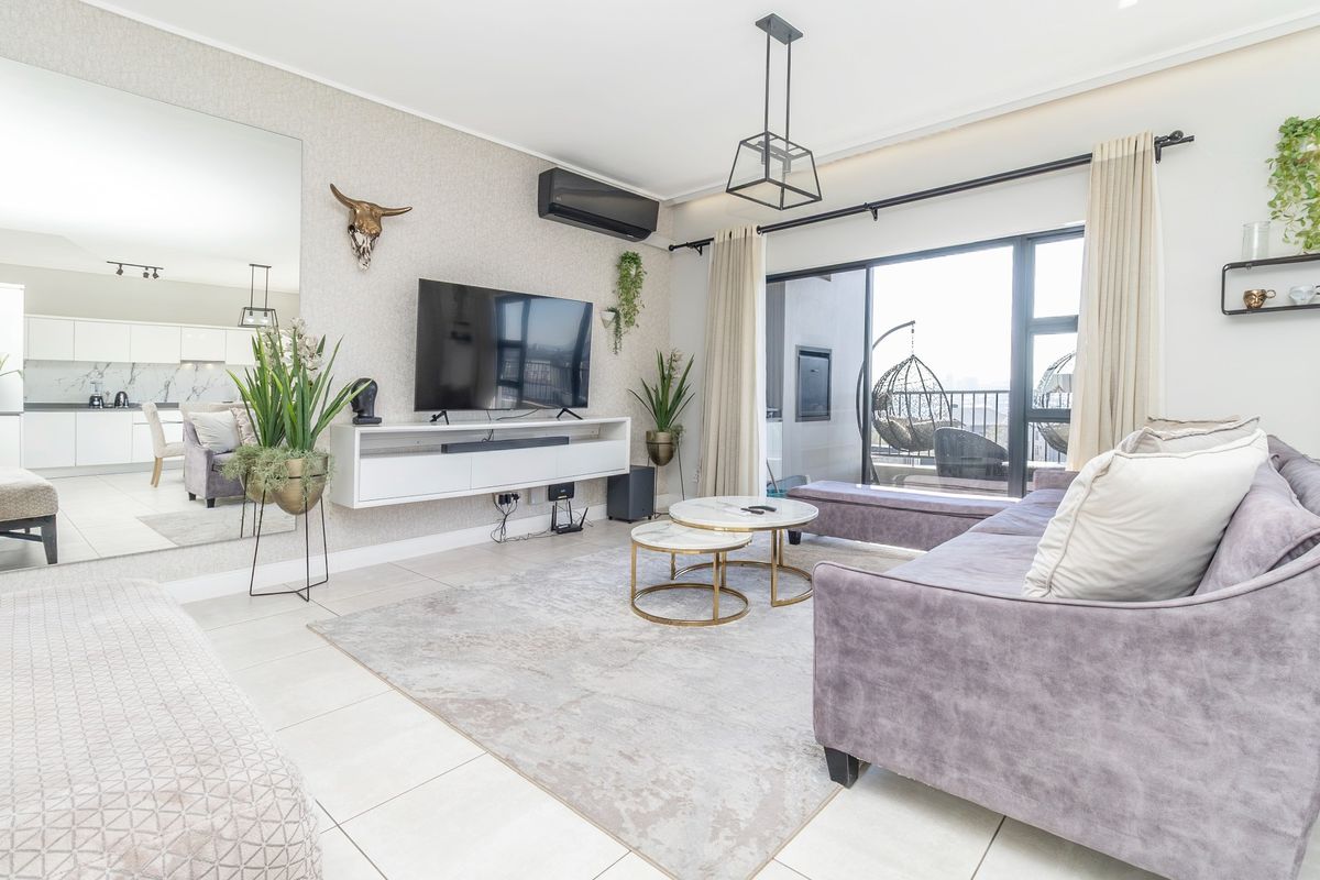 Modern living room featuring tiled floors, a wall-mounted air conditioning unit, a large feature mirror, and direct access to a balcony through sliding glass doors.