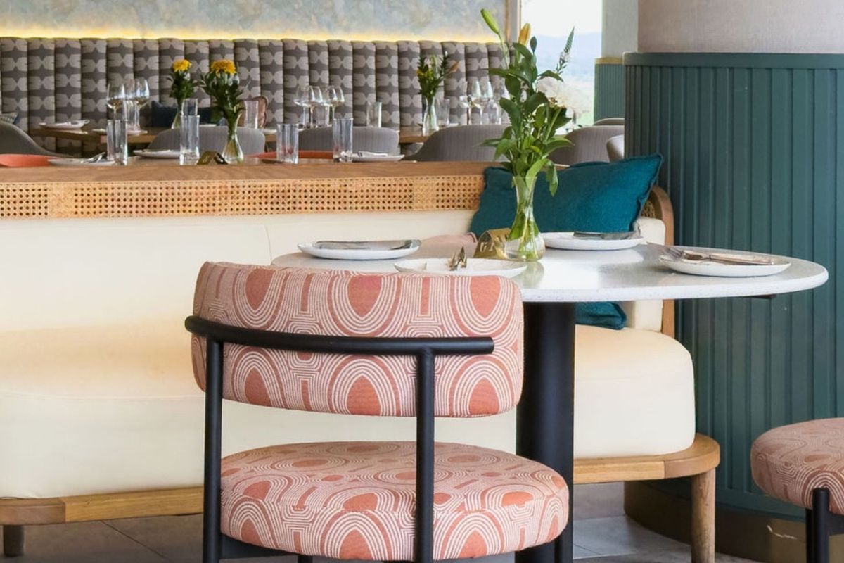 A stylishly designed interior space featuring custom upholstered banquette seating, decorative wainscoting, and modern recessed lighting, creating a sophisticated and inviting atmosphere.