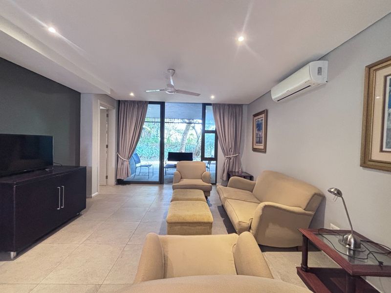 Spacious living room featuring tiled flooring, recessed lighting, a ceiling fan, and a split-system air conditioner, with direct access to an outdoor patio area.