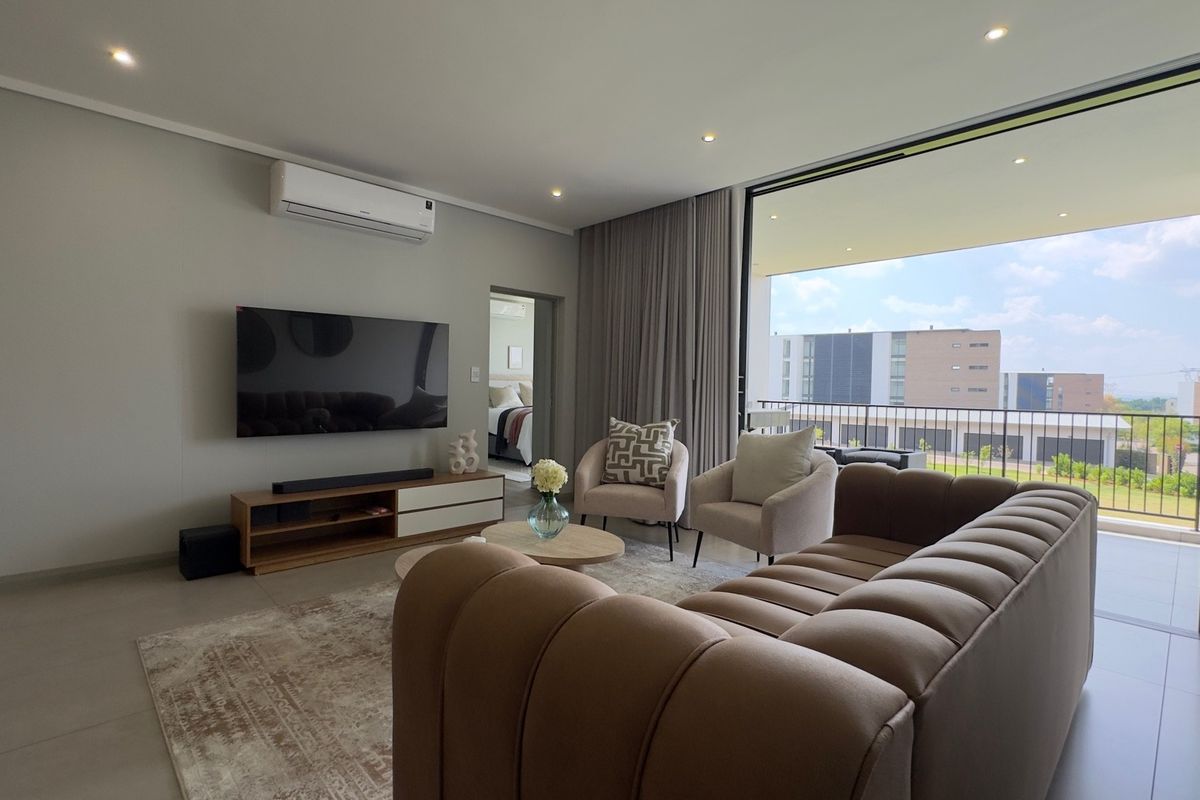 Modern living room featuring tiled floors, recessed lighting, and a split-system air conditioner, with seamless access to a private balcony.