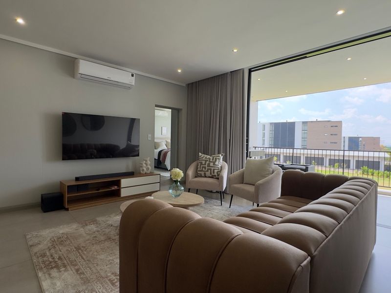 Modern living room featuring tiled floors, recessed lighting, and a split-system air conditioner, with seamless access to a private balcony.