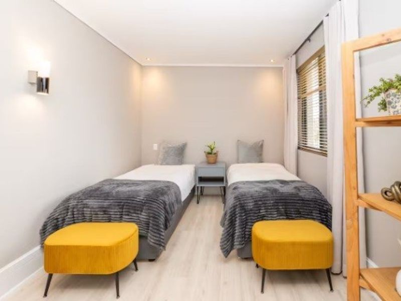 A well-maintained bedroom featuring neutral walls, laminate flooring, recessed lighting, and venetian blinds, providing a clean and comfortable living space.