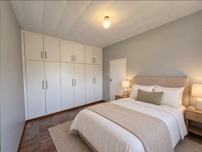 A well-maintained bedroom featuring extensive built-in floor-to-ceiling cupboards, tiled flooring, and a neutral color palette.