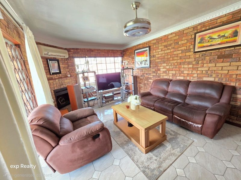 A living room featuring exposed brick walls, tiled flooring, a ceiling fan, and a built-in fireplace, providing a rustic and cozy atmosphere.