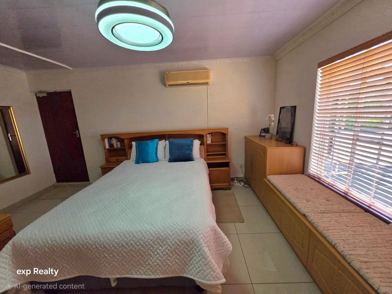 A bedroom featuring tiled flooring, a built-in headboard with integrated shelving, a window seat, and an air conditioning unit.