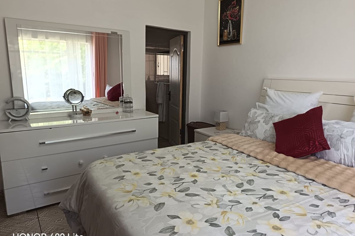 A well-lit bedroom featuring tiled flooring and direct access to an en-suite bathroom, providing a functional and comfortable living space.