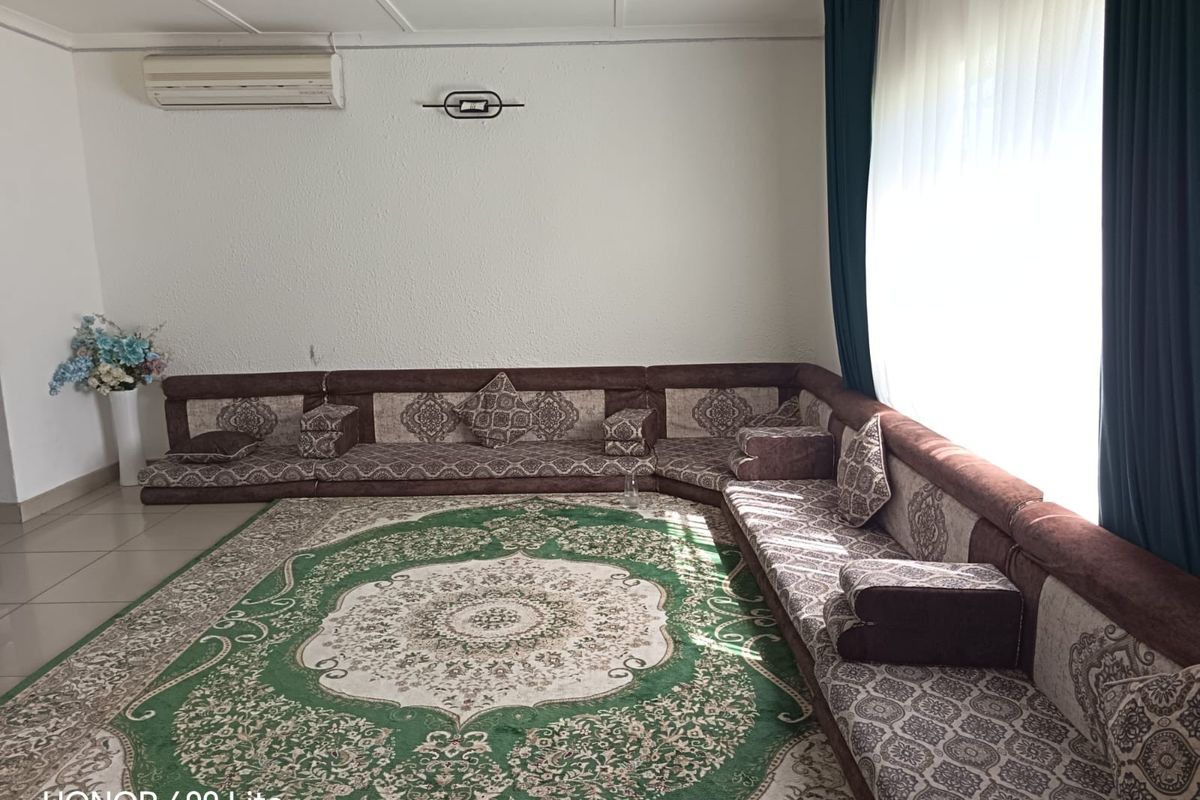 A living room featuring tiled flooring and a wall-mounted split-system air conditioner.