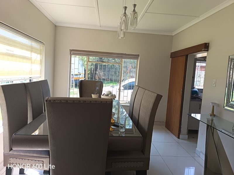 A dining room featuring tiled flooring, ceiling paneling, and a sliding door leading to the exterior.