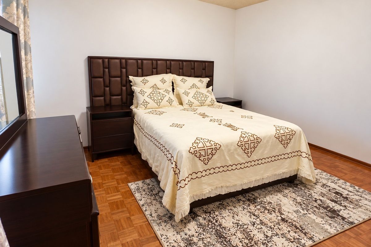 A bedroom featuring classic parquet wood flooring and neutral wall finishes, providing a clean and functional space.